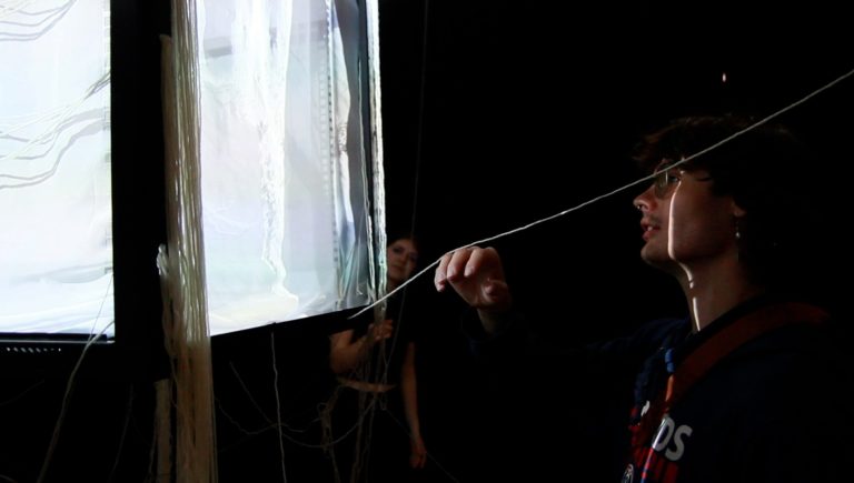 BA Animation and VFX work by Ruby Snell showing a person touching thread that hangs from a suspended installation.