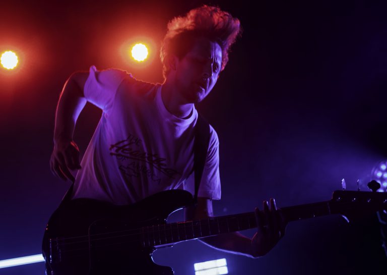 BA Photography Work by Amber Hill showing a guitarist immersed in the music he is performing, with the use of slight motion blur.