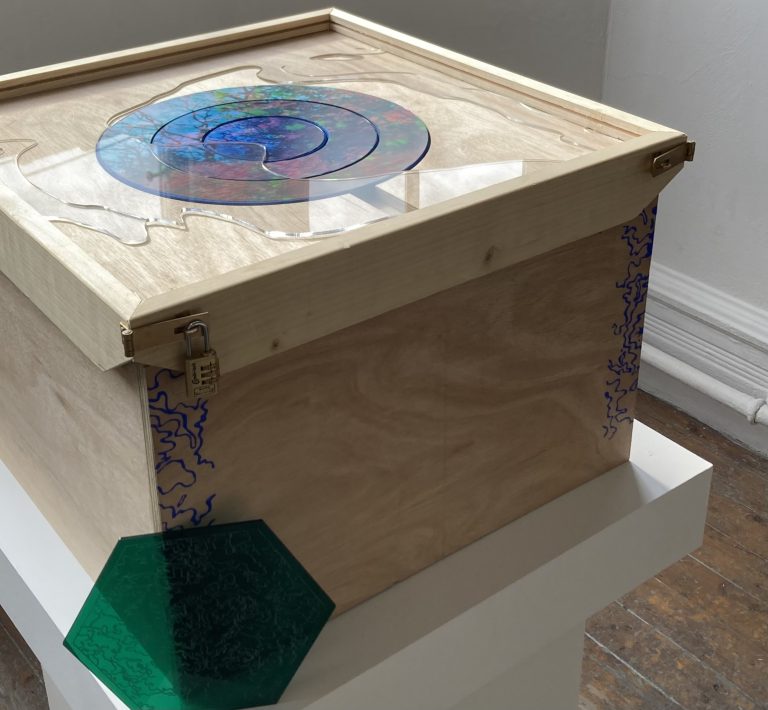 MA Games work by Merle Hompesch showing a wooden box with a colourful circular puzzle on the top.