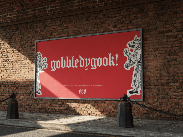 A red billboard advertisement with a demon and lady on either side of the word gobbledygook.