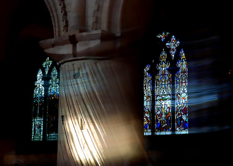 BA Fine Art photo by Anya Gant showing two stained-glass windows in a cathedral. The use of long exposure has made the light in the windows look smeared across the photo.