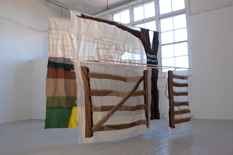 BA Fine Art textile piece by Laurie Millings, depicting a large-scale multi-layered landscape view of Norfolk behind a gate.