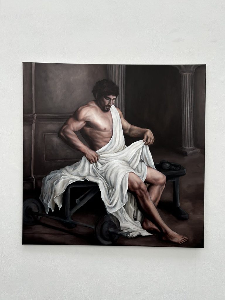 Millie Hornsby BA Fine Art presents a Baroque-inspired painting displayed in a gallery setting, depicting a muscular man draped in white fabric seated among gym weights with dramatic lighting and classical architecture.